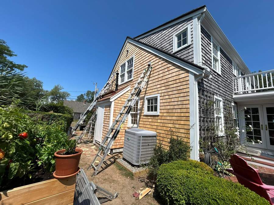 Freshly installed cedar shingle siding and new white trim on a South Shore home by CB Builders Corp.