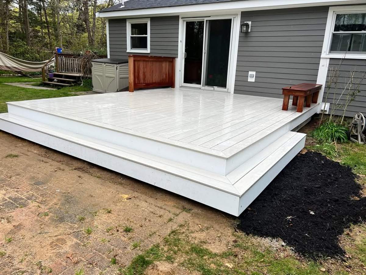 Clean white composite deck and gray siding on a South Shore home by CB Builders Corp.