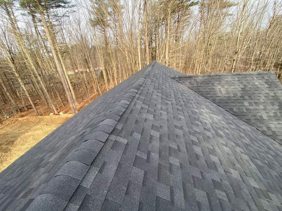 Finished architectural asphalt shingle roof and ridge on a wooded South Shore lot by CB Builders Corp.